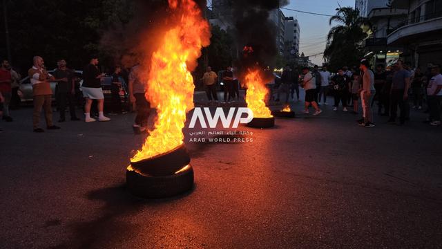مالكو دراجات نارية لبنانية في مدينة صيدا جنوب لبنان يشعلون إطارات سيارات أثناء احتجاج على قانون يمنع قيادة الدراجات النارية مؤقتا في المدينة (17 أبريل نيسان 2024)