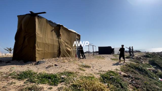  خيمة النازح الفلسطيني عماد أبو زيد عند شاطئ البحر في دير البلح بقطاع غزة، حيث صنع من خامات المظلات التي تلقى بها المساعدات من الجو للنازحين خيمة تأويه وعائلته المكونة من 10 أشخاص (14 أبريل نيسان 2024)