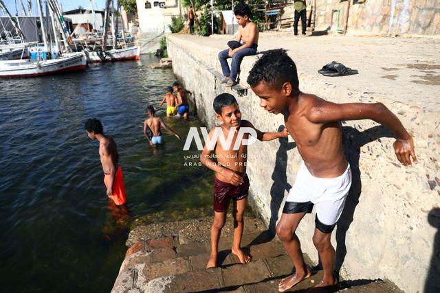 أطفال مصريون يسبحون في مياه نهر النيل بأسوان في جنوب البلاد وسط موجة الحر الشديد التي تشهدها المدينة، حيث بلغت درجة الحرارة 42 مئوية (24 أبريل نيسان 2024)