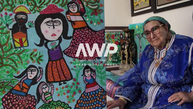  المغربية زهرة أبو علي مع واحدة من لوحاتها في منزلها بالعاصمة الرباط حيث لا تزال ترسم لوحات تعكس جذورها وعائلتها والأحداث التي عاشتها على مدار 95 عاما من عمرها (20 مارس آذار 2024)