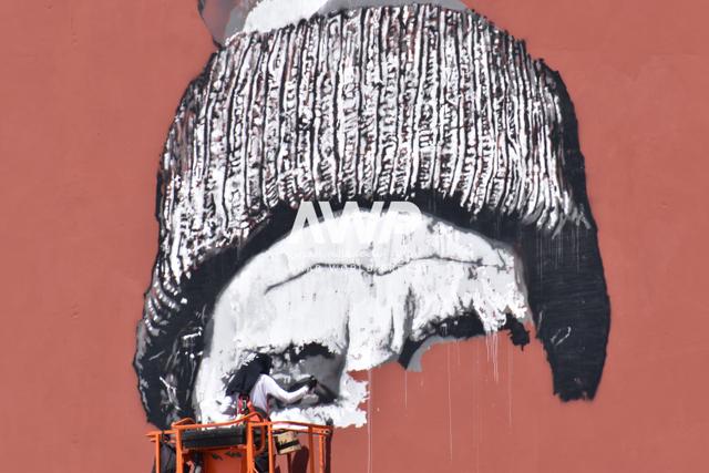 awp - الفنان الألماني هندريك بيكيرش (يمين) أثناء عمله في إعادة تجديد جداريته التي تحمل اسم "الوجه البشوش" في مدينة مراكش بالمغرب، حيث كان قد رسمها للمرة الأولى عام 2015 على واجهة عمارة في المدينة (24 أبريل نيسان 2024)