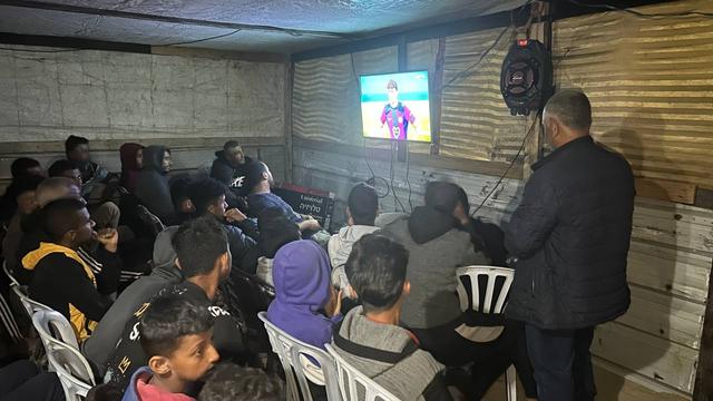 نازحون يتابعون مبارة لكرة القدم في مقهى في خان يونس بقطاع غزة. الاثنين، 22 أبريل نيسان 2024